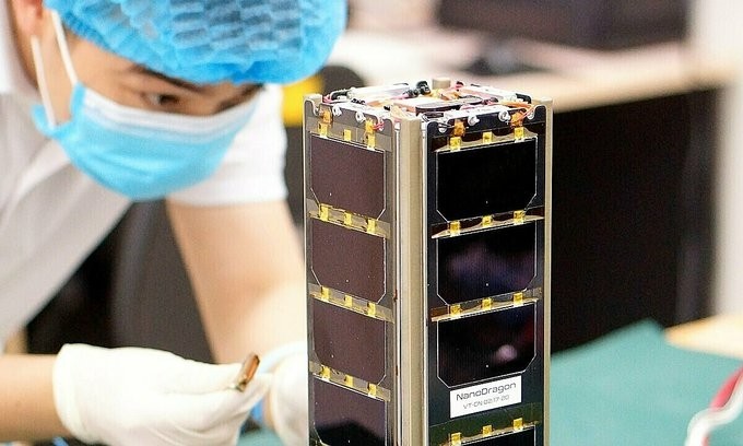 A staff member of the Vietnam National Space Centre works on the NanoDragon satellite. (Photo: VNSC)
