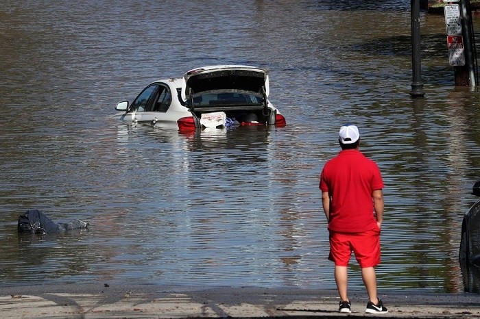 A man looks at a car in floodwaters after remnants of Ida brought drenching rain, flash floods and tornadoes to parts of the Northeast in Mamaroneck, New York, September 2, 2021. (Photo: Reuters)