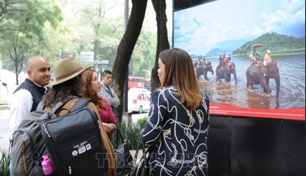 Visitors admiring a photo on display at the exhibition (Photo: VNA)