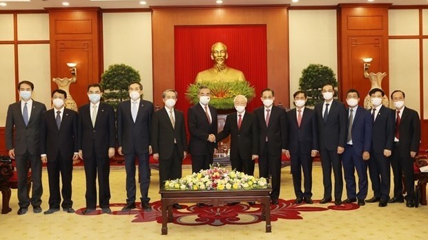 Party General Secretary Nguyen Phu Trong and State Councilor and Foreign Minister of China Wang Yi pose for a photo with other officials. (Photo: VNA)