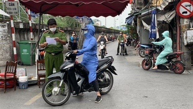 A police officer inspects documents at a checkpoint in Chuong Duong ward (Photo: VNA)