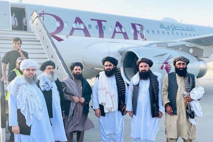 Taliban delegates in front of a Qatar Airways plane in Afghanistan, on Oct 8, 2021. (Photo: Reuters)