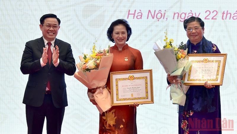 Current NA Chairman Vuong Dinh Hue presented the 40-year Party membership insignia and flowers to former NA Chairwoman Nguyen Thi Kim Ngan and former NA Vice Chairwoman Tong Thi Phong. (Photo: Duy Linh)