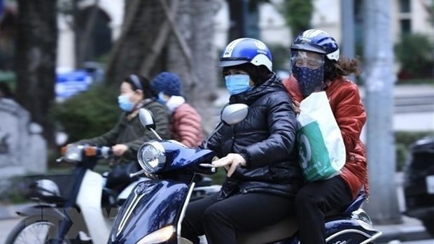 People ride scooters in cold weather (Photo: VNA)