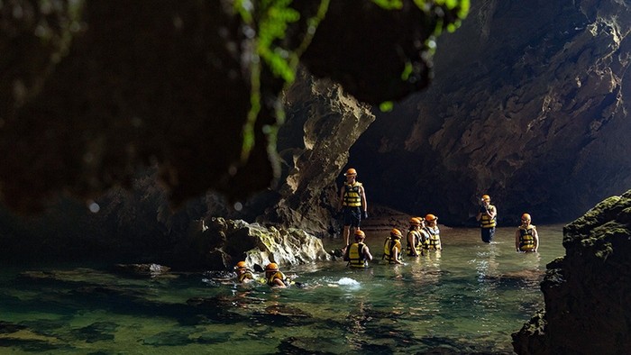 Visitors swim through the underground river during the tour to Tiger cave, in Phong Nha-Ke Bang National Park. (Photo: Hai Lam)