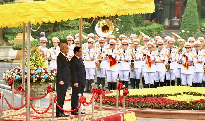 Prime Minister Pham Minh Chinh and Malaysian Prime Minister Dato’ Sri Ismail Sabri bin Yaakob listen to the two countries' national anthems.