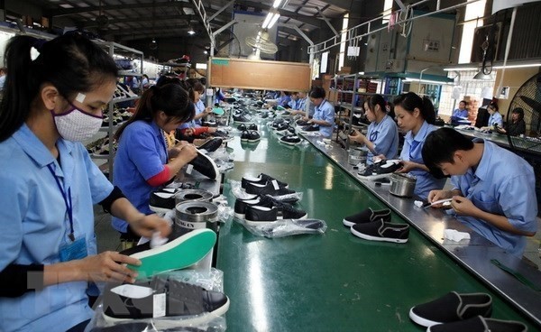 Producing footwear for export (Photo: VNA)