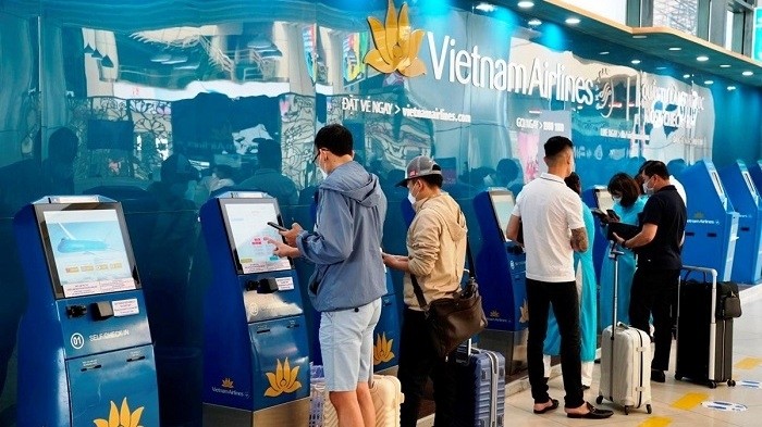 Passengers using automatic check-in kiosks for Vietnam Airlines (Photo: VNA)