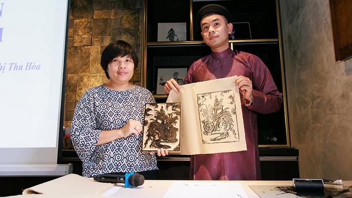 Researcher Nguyen Thi Thu Hoa (left) introduces a sample of spiritual painting. (Photo: NDO)