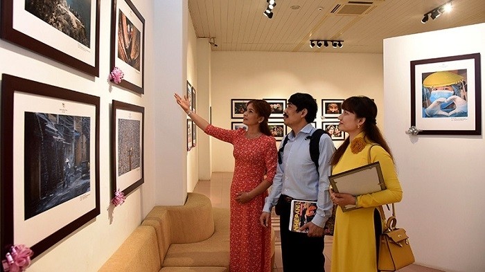 Visitors admiring a photo on display at the exhibition