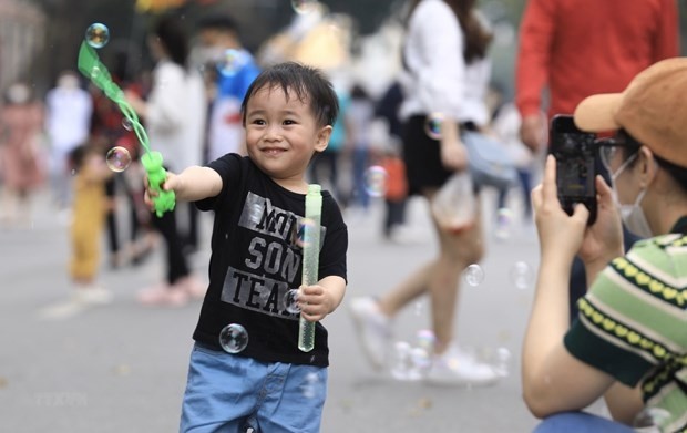 A boy happy playing with bubbles on Hoan Kiem Lake pedestrian street (Photo: VNA)