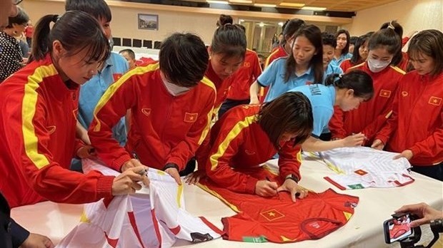 The Vietnamese players sign their autographs for fans. (Photo: VNA)