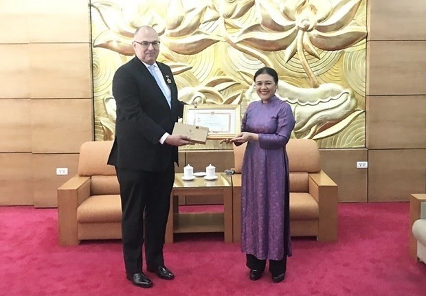 Danish Ambassador to Vietnam Kim Højlund Christensen (L) receives the insignia “For peace and friendship among nations” (Photo:VNA) 
