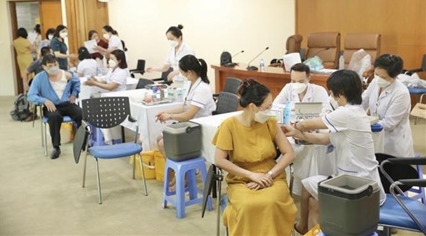 State employees and workers receive COVID-19 booster shots after the launching ceremony. (Photo: VNA)
