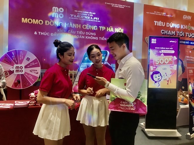 A visitor tries a cashless payment service at the event in Hanoi on July 21 (Photo: VNA)