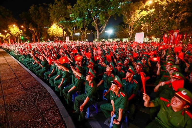 Young soldiers wave the national flag at the event in Hanoi. (Photo: DUY LINH)