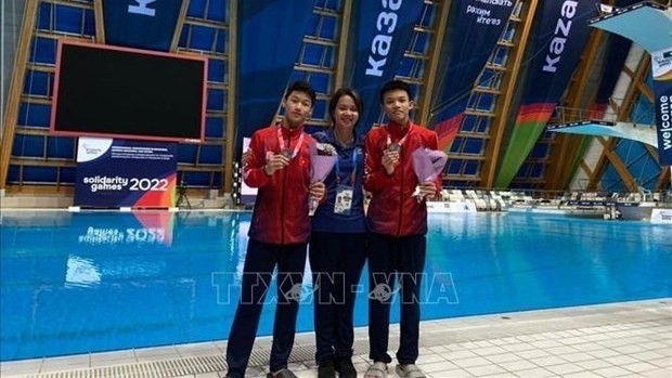Dang Hoang Tu (R), Dinh Anh Tuan (L) and their coach Hoang Thanh Tra (Photo: VNA)