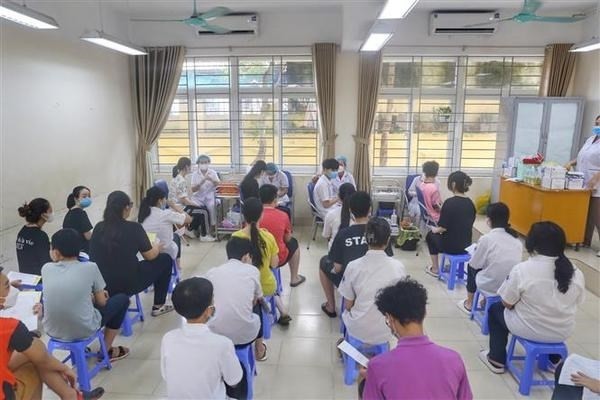 Medical staff give COVID-19 vaccine shots to students of Ha Huy Tap secondary school in Hanoi (Photo: VNA)