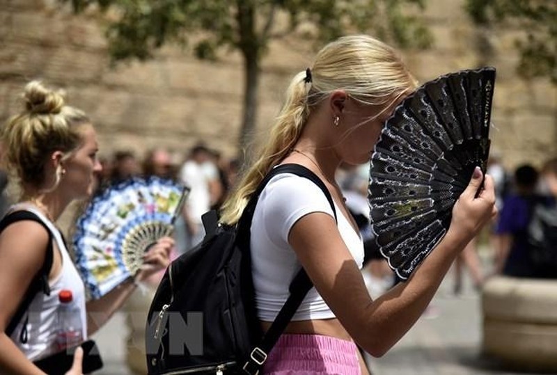 People cool off as the temperature rises in Seville, Spain on June 13, 2022. (Source: AFP/VNA)