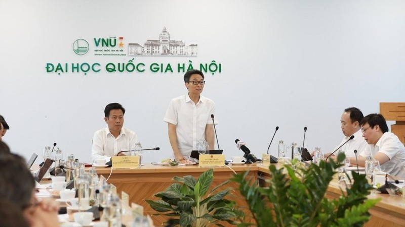 Deputy Prime Minister Vu Duc Dam (R) speaks at the working session with the VNU-HN on August 16.