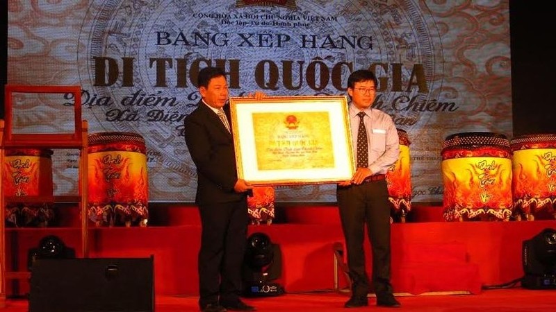 Representative from Dien Ban district's authorities receives a certificate honouring Thanh Chiem Palace as a national relic site. (Photo: baoquangnam.vn)