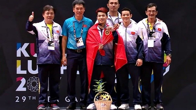 Trinh Van Vinh celebrates his 62kg title with other members of the weightlifting team.