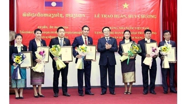 Head of the Communist Party of Vietnam Central Committee's Commission for External Affairs Hoang Binh Quan presents the “For the cause of the Party's foreign affairs” to seven Lao officials. (Photo: VOV)