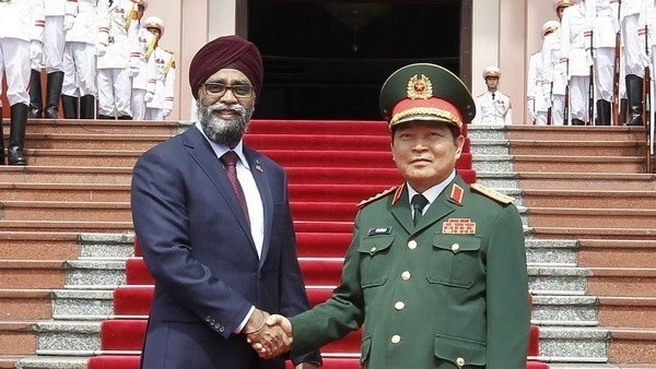 Vietnamese Minister of National Defence Ngo Xuan Lich (R) welcomes his Canadian counterpart Harjit Singh Sajjan in Hanoi on June 5 (Photo: VNA)