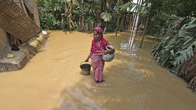 A woman carries drinking water after collecting it from a hand pump at a flood affected area in Hojai district, in the northeastern state of Assam, India, June 17, 2018. (Photo: Reuters)