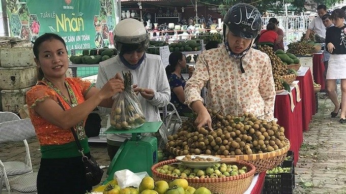 Visitors buy Son La longan at the opening ceremony of the safe farm produce week on August 3. (Photo: VOV)