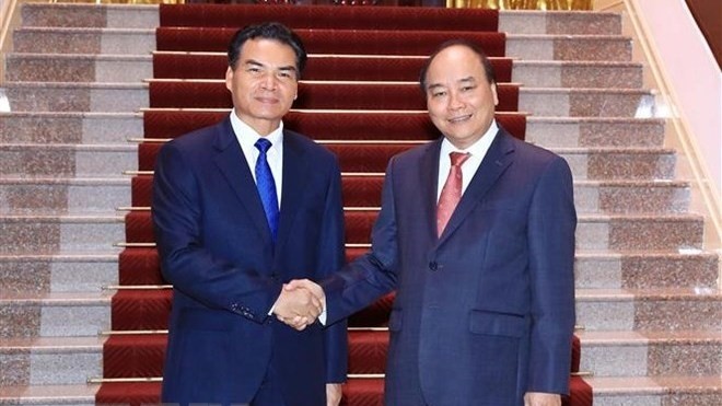 Prime Minister Nguyen Xuan Phuc (R) and Minister, Chairman of the Lao Government Office Phet Phomphiphak (Photo: VNA)