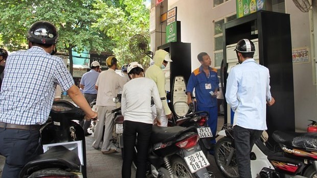 Motorcyclists line up to buy petrol at a station of Petrolimex. (Photo: VNA)