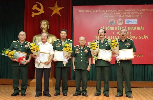 Maj. Gen. Vo So, President of the Truong Son - Ho Chi Minh Trail Traditional Association, presents the collective prizes to the winners.