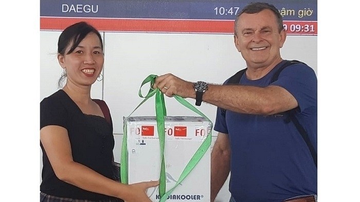 Dr. Edward Kondrot (R) hands over the corneas to a representative from the National Coordination Centre for Organ Transplantation at Da Nang Airport on June 2. (Photo: NDO/Lam Tran)