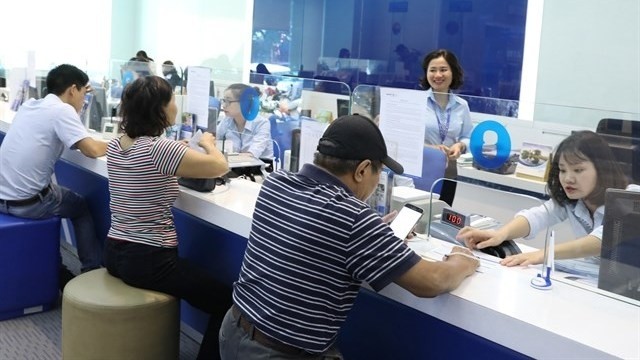 Customers make transaction at Bao Viet Bank in Hanoi’s Tran Hung Dao Street.(Photo: VNA)