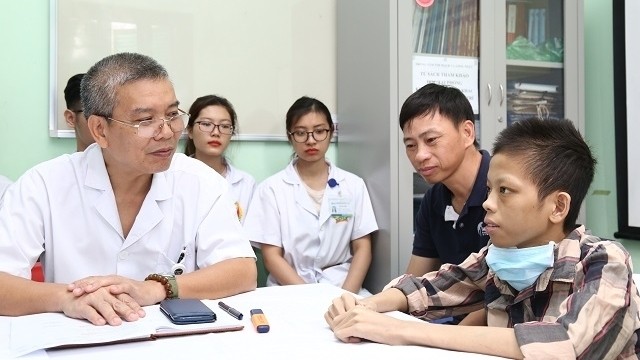 Assoc. Prof., Dr. Nguyen Huu Uoc, Head of the Cardiovascular and Thoracic Surgery Centre under the Viet Duc Hospital, advising his patient (far right) and his family members before leaving the hospital.