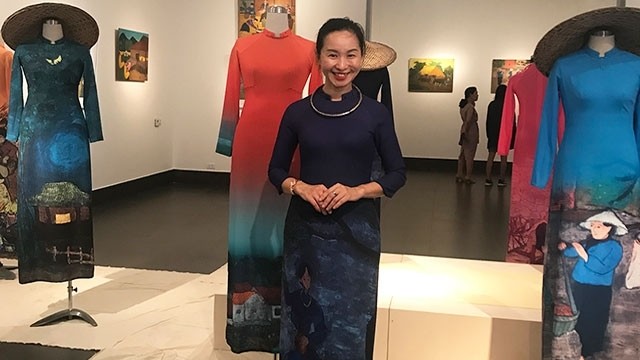 Painter Vi Viet Nga standing in front of her Ao Dai designs on display at the exhibition (Photo: Vu Anh)