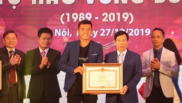 Minister of Culture, Sports and Tourism Nguyen Ngoc Thien (second from right) presents the Prime Minister’s Certificate of Merit to Vietnam’s top tennis star Ly Hoang Nam. (Photo: VTF)