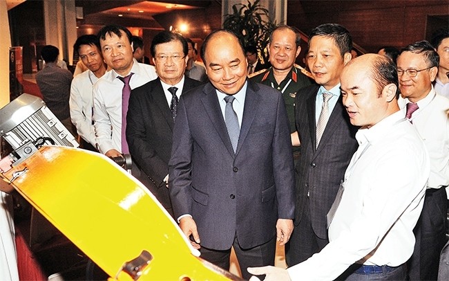 Prime Minister Nguyen Xuan Phuc (C) visits a booth introducing products by Vietnam's mechanical engineering industry. (Photo: NDO/Tran Hai)
