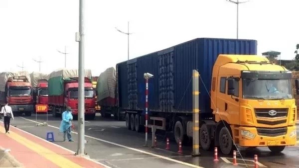 Trucks are crossing the Vietnam-China border through the Bac Luan II Bridge after customs clearance.
