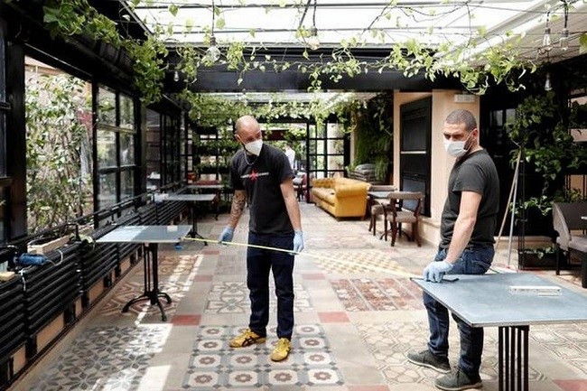  Employees of Michelin-starred "Marco Martini" restaurant use a tape measure to check the distance between tables as they reorganise the restaurant to comply with social distancing rules due to coronavirus disease (COVID-19), ahead of reopening next week in Rome, Italy on May 14, 2020. (hoto Credit: Reuters) 