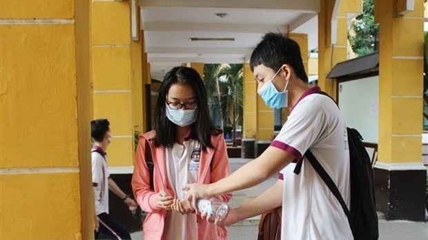 Students wash their hands with sanitizer (Photo: VNA)
