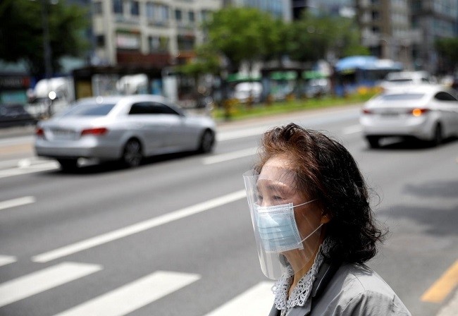A woman in a face shield and mask waits to cross a street, amid the spread of the coronavirus disease (COVID-19), in Seoul, ROK, May 28, 2020. (Photo: Reuters)
