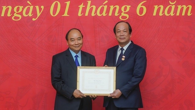 Prime Minister Nguyen Xuan Phuc (L) awards the 40-year Party membership badge to Minister-Chairman of the Government Office Mai Tien Dung. (Photo: baochinhphu.vn)