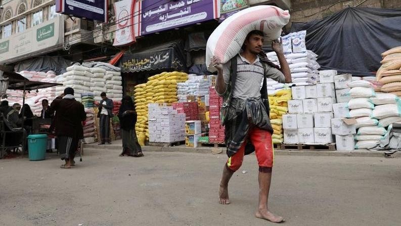A woker carries a sack of wheat flour outside a food store amid concerns over the spread of the coronavirus disease (COVID-19), in Sanaa, Yemen May 13, 2020. (Photo: Reuters)