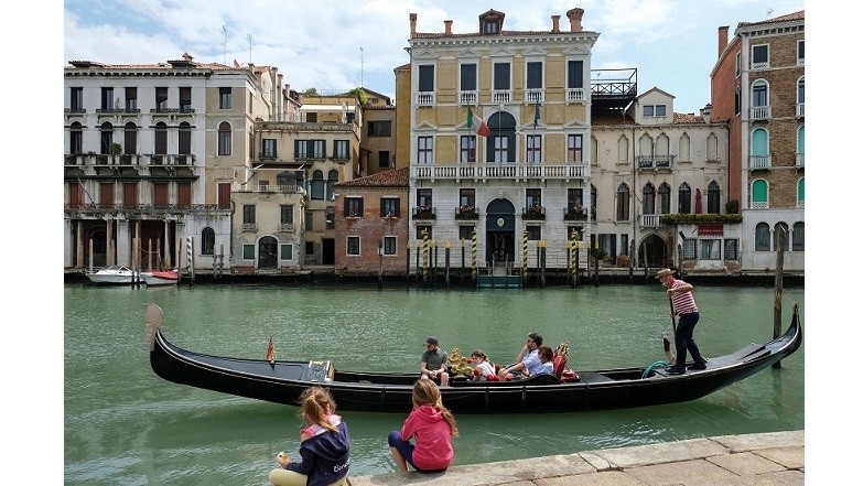 Children look a a gondola with passengers as gondoliers officially resume work for the first time since Italy's strict coronavirus disease (COVID-19) lockdown, in Venice, Italy, May 30, 2020.