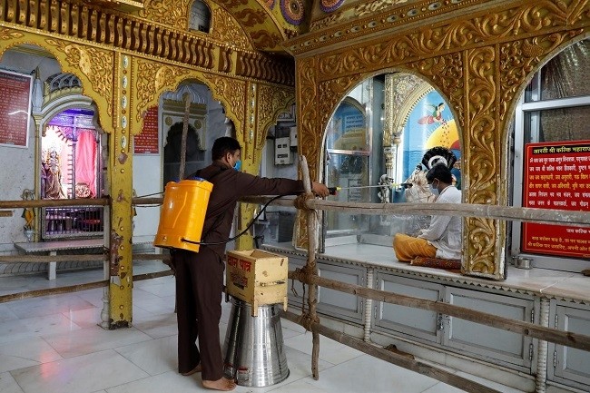 A man disinfects a temple after the opening of most of the religious places after India eases lockdown restrictions that were imposed to slow the spread of the coronavirus disease (COVID-19), in New Delhi, India, June 8, 2020. (Photo: Reuters)