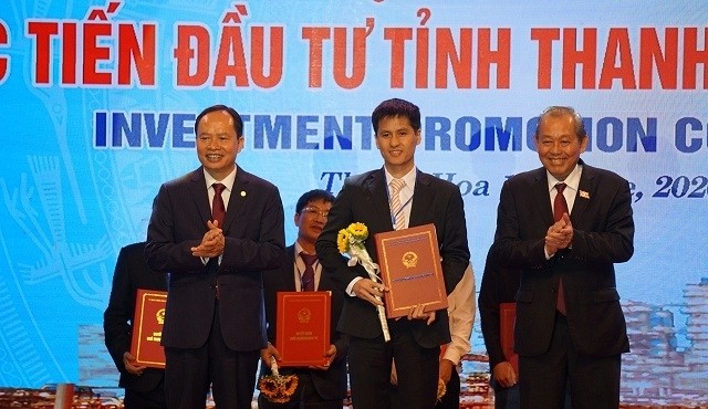 Deputy PM Truong Hoa Binh (right) and Thanh Hoa province's leader grant investment certificates to investors.