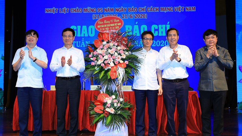 Deputy PM Vu Duc Dam (third from right) presents flowers to congratulates journalists on the occasion of Vietnam Revolutionary Press Day. (Photo: VGP)