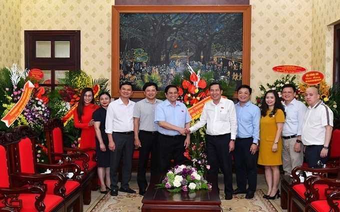 Politburo member Pham Minh Chinh (fifth from left) congratulates Nhan Dan Newspaper. 